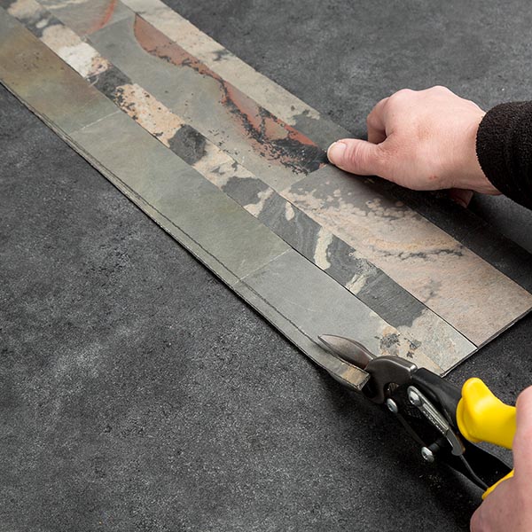 Cut the tile along the scribed line using a tin snips